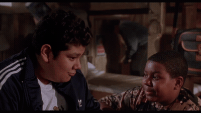 Two Boys Are Sitting Next To Each Other With The Words This Pleases Me Behind Them GIF