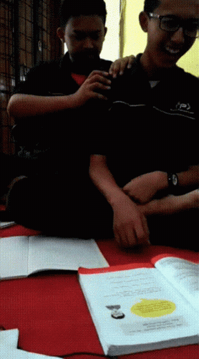 Two Boys Are Sitting On The Floor With One Wearing A Shirt That Says ' Jsp ' On It GIF