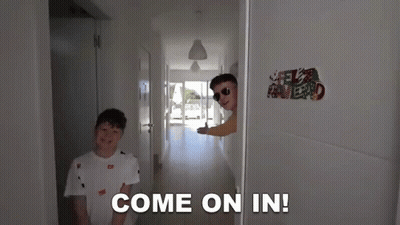 Two Boys Are Standing In A Hallway And One Of Them Says Come On In GIF