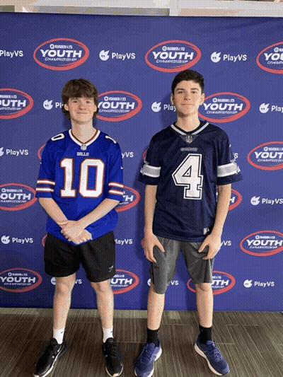 Two Boys Are Standing In Front Of A Wall That Says Playvs Youth GIF