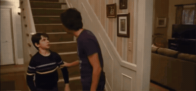 Two Boys Are Standing On A Set Of Stairs And One Of Them Is Wearing A Striped Shirt GIF