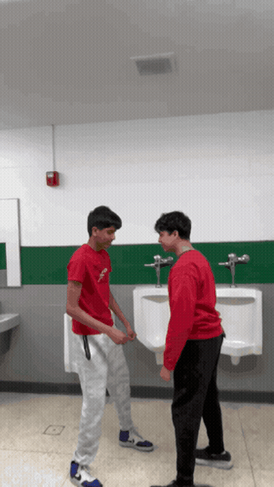 Two Boys In Bathroom One Wearing Red Jesus Shirt GIF