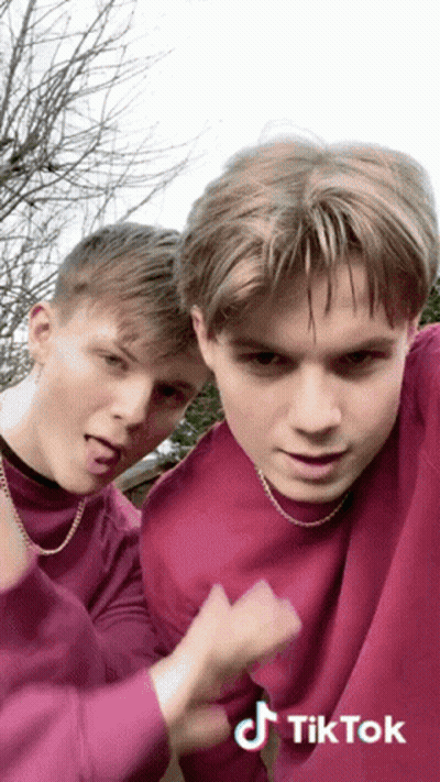 Two Boys In Purple Sweaters Making Funny Faces GIF