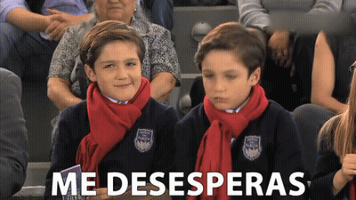 Two Boys In Scarves Sitting In Crowd Saying Me Desesperanzas GIF