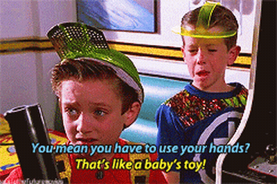 Two Boys Playing Arcade Game One In Green Hat GIF