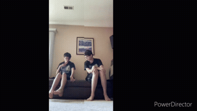 Two Boys Sitting On Couch In Front Of Wall With Picture GIF