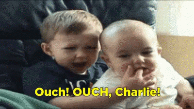 Two Boys Sitting With Words Ouch Ouch Charlie In Yellow GIF