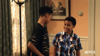 Two Boys Standing In Living Room With Netflix Logo GIF