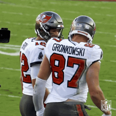 Two Buccaneers Football Players Greet Each Other On The Field During A Game GIF