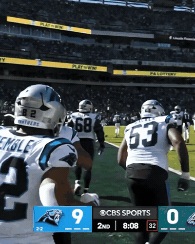 Two Carolina Panthers Players In White And Blue Uniforms GIF