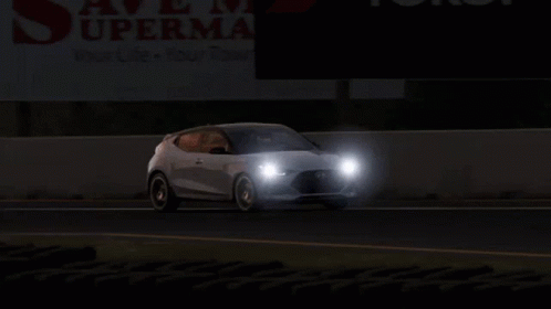 Two Cars Are Driving Down A Road In Front Of A Sign That Says Supermart GIF