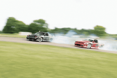 Two Cars Are Racing On A Track And One Is Red GIF