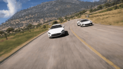 Two Cars Driving Down Road With Mountains GIF