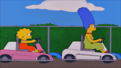 Two Cartoon Characters , Lisa Simpson And Marjorie Simpson , Are Riding Go Karts . GIF