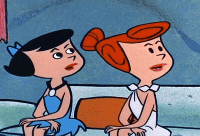 Two Cartoon Characters Sitting Next To Each Other With One Having A S On Her Head GIF