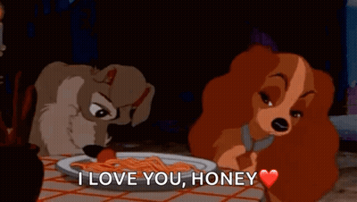 Two Cartoon Dogs Sitting At Table With Spaghetti And Tomato GIF
