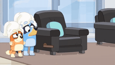 Two Cartoon Dogs Wearing Towels On Their Heads Standing Next To A Chair GIF
