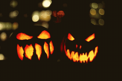 Two Carved Pumpkins With Glowing Faces GIF