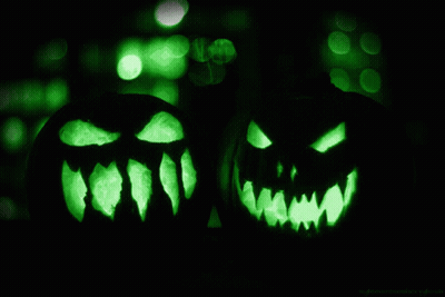 Two Carved Pumpkins With Glowing Faces In Dark GIF