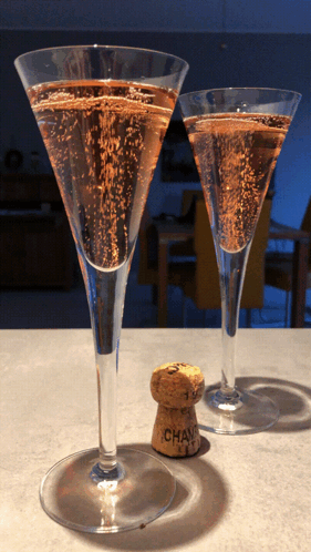 Two Champagne Glasses With A Cork That Says Chandon GIF