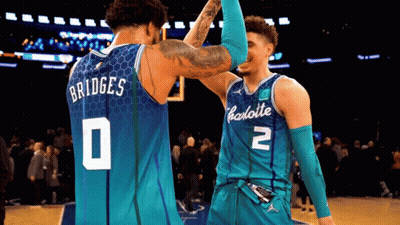 Two Charlotte Basketball Players High Five Each Other On The Court GIF
