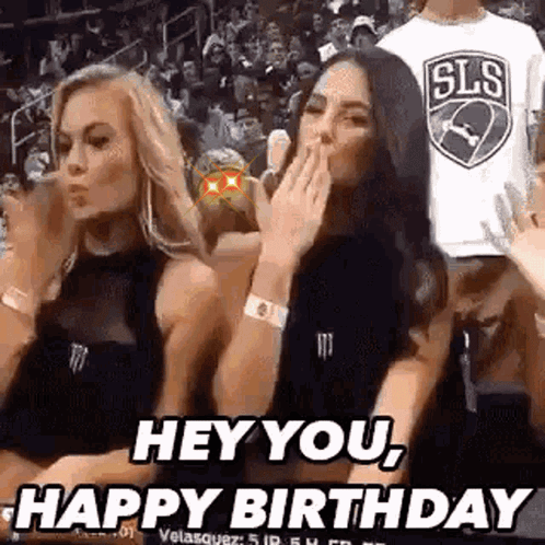 Two Cheerleaders Are Sitting In The Stands At A Basketball Game And Covering Their Mouths With Their Hands . GIF