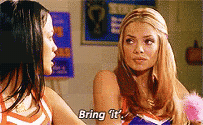 Two Cheerleaders Are Talking To Each Other And One Of Them Is Saying Bring It GIF