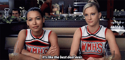 Two Cheerleaders From Wmhs Are Sitting Next To Each Other In A Diner GIF