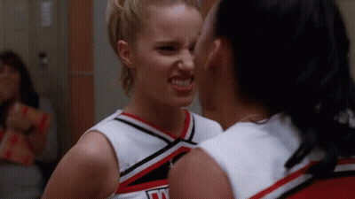 Two Cheerleaders Looking At Each Other, One Wearing Jersey Saying N GIF