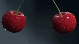 Two Cherries Are Falling Into The Water With Bubbles GIF