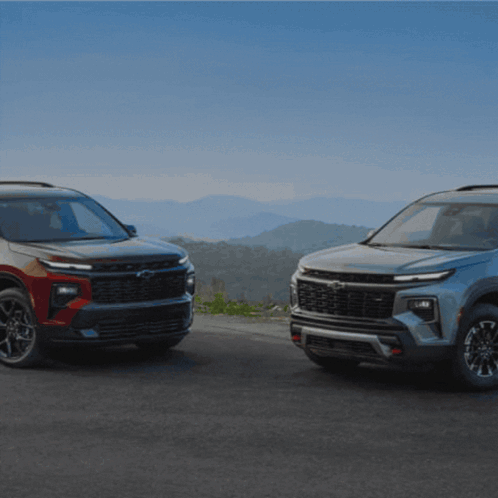 Two Chevrolet SUVs Parked On Mountain Road GIF