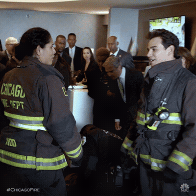 Two Chicago Firefighters Talking In Front Of Crowd GIF