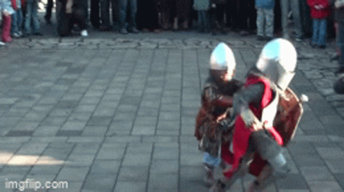 Two Children Dressed Up As Knights Are Dancing On A Brick Sidewalk GIF