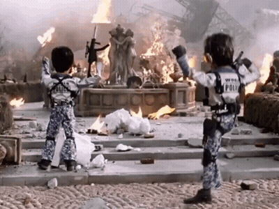 Two Children In Police Uniforms Before Burning Building GIF