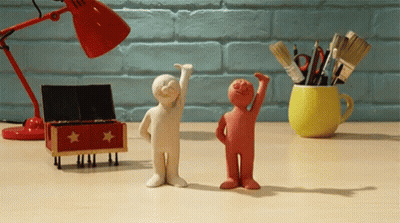 Two Clay Figures Standing Together GIF