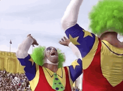 Two Clowns Are Standing Next To Each Other In Front Of A Crowd In A Stadium . GIF