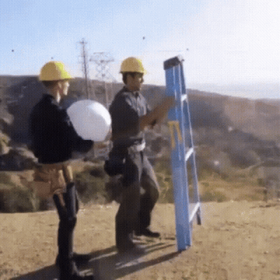 Two Construction Workers Standing Next To Ladder GIF