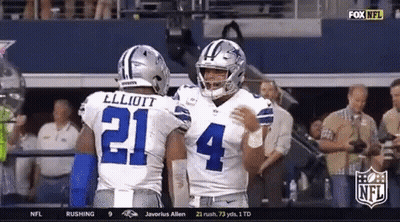 Two Cowboys Football Players Are Hugging Each Other In The Stands GIF