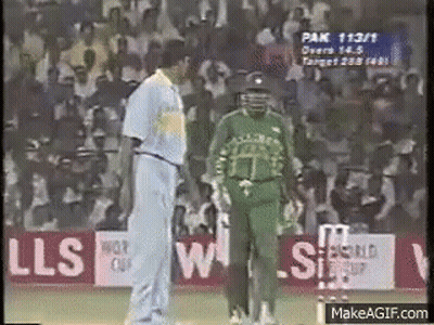 Two Cricket Players Are Talking To Each Other On A Field . GIF