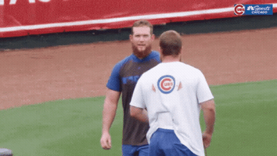 Two Cubs Players Are Standing On A Baseball Field GIF
