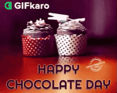 Two Cupcakes Are Sitting On A Table With The Words Happy Chocolate Day Written Above Them . GIF