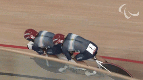 Two Cyclists Wearing Giro Helmets Are Riding A Tandem Bike GIF