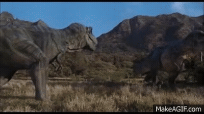 Two Dinosaurs Are Standing Next To Each Other In A Field In Front Of Mountains . GIF