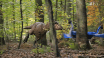 Two Dinosaurs Walking Through Forest With Apple TV+ Logo GIF