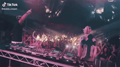 Two DJs Playing Music in Front of Crowd With TikTok Logo