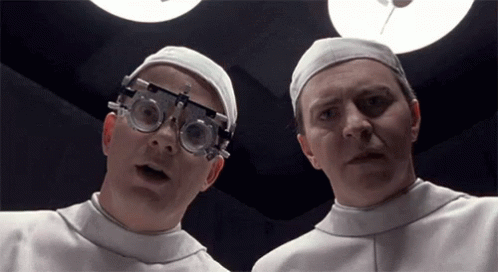 Two Doctors In Surgical Caps And Goggles GIF