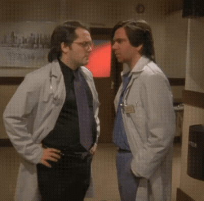 Two Doctors Shaking Hands By Emergency Room Sign GIF