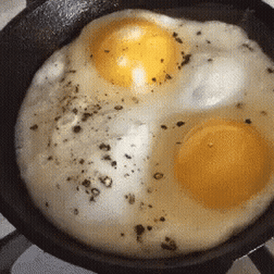 Two Eggs Being Cooked in a Pan