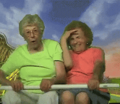 Two Elderly Women Are Riding A Roller Coaster Together And One Is Covering Her Face . GIF