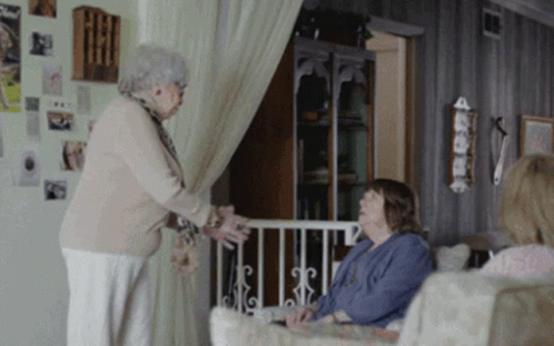 Two Elderly Women Are Standing In A Living Room Talking GIF